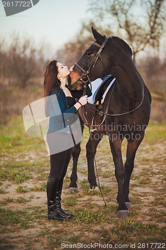Image of Young woman with a horse on nature
