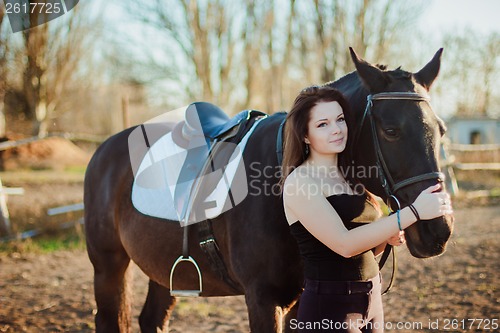 Image of Young woman with a horse on nature