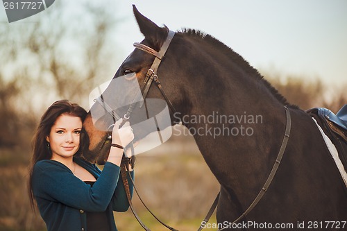 Image of Young woman with a horse on nature