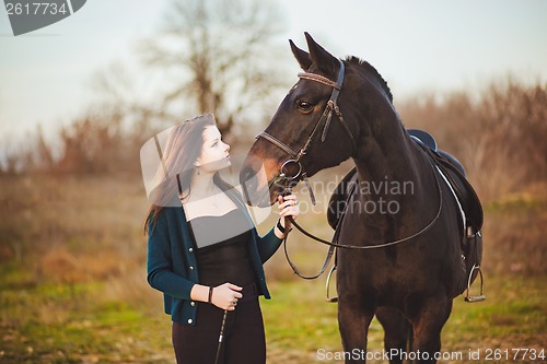 Image of Young woman with a horse on nature