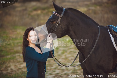 Image of Young woman with a horse on nature