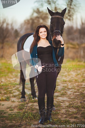 Image of Young woman with a horse on nature