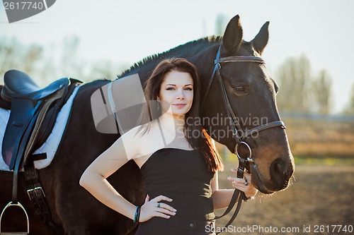 Image of Young woman with a horse on nature