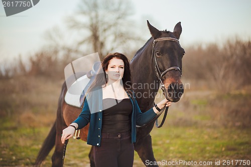 Image of Young woman with a horse on nature