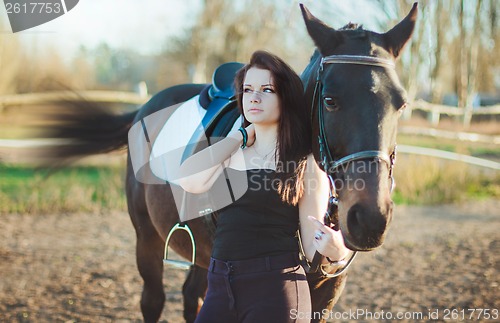 Image of Young woman with a horse on nature