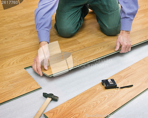 Image of Man laying laminated panels color of wood