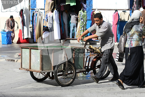 Image of Man pushing a tricycles