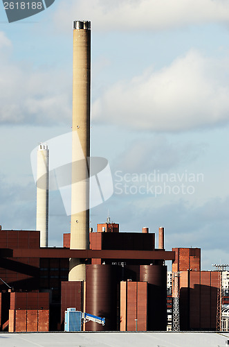 Image of industrial building and chimney against the sky