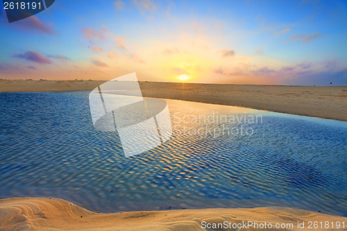 Image of Sunrise over golden sands and azure waters