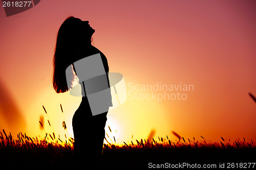 Image of Woman relaxing at sunset