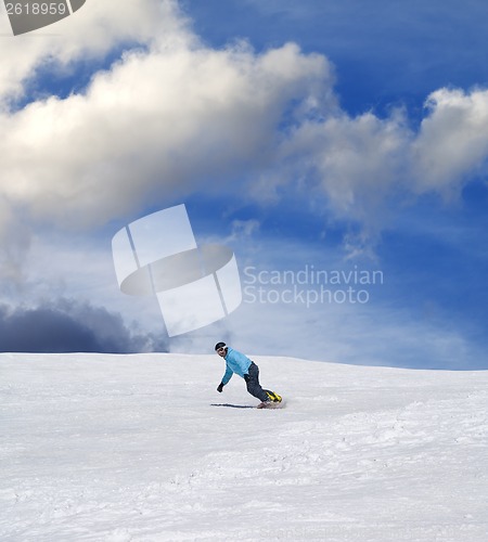 Image of Snowboarder on ski slope and blue sky