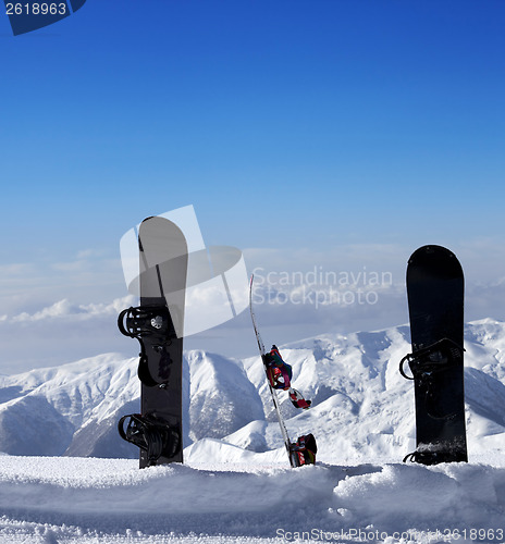 Image of Three snowboards in snow near off piste slope in sun day
