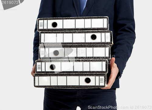 Image of Business man carrying folders