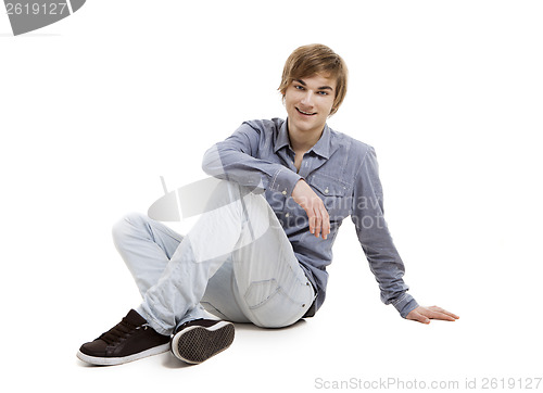 Image of Young man sitting on the floor