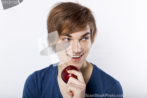 Image of Young man eating a apple