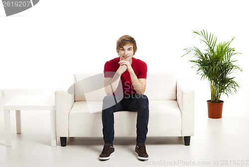 Image of Young man sitting on the couch