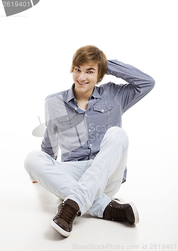 Image of Young man sitting on the floor