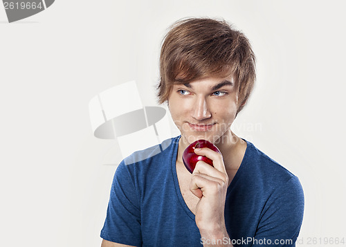 Image of Young man eating a apple