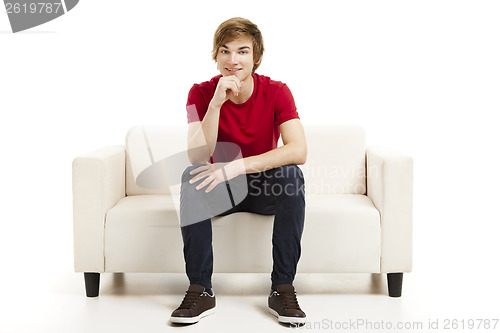 Image of Young man sitting on the couch