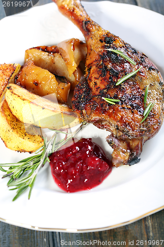 Image of Duck leg with potatoes and cowberry sauce. 
