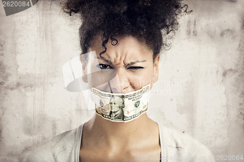 Image of Covering mouth with a dollar banknote