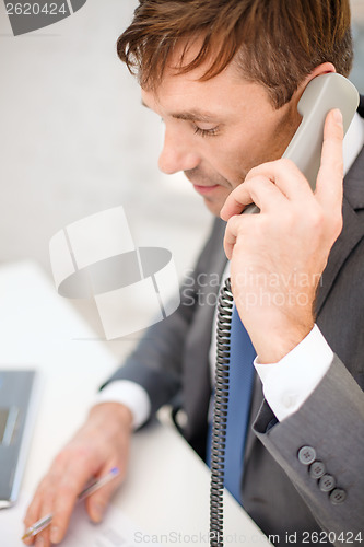 Image of businessman with laptop computer and phone