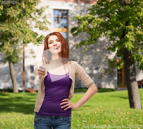 Image of smiling girl in casual clothes showing thumbs up