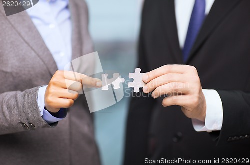 Image of businessman and businesswoman with puzzle pieces