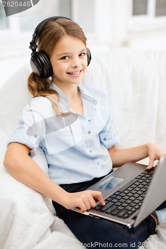 Image of girl with laptop computer and headphones at home