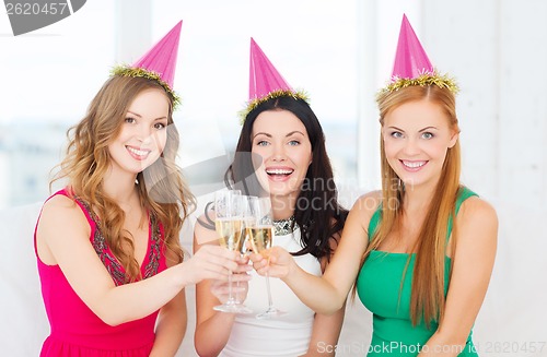 Image of three women wearing hats with champagne glasses