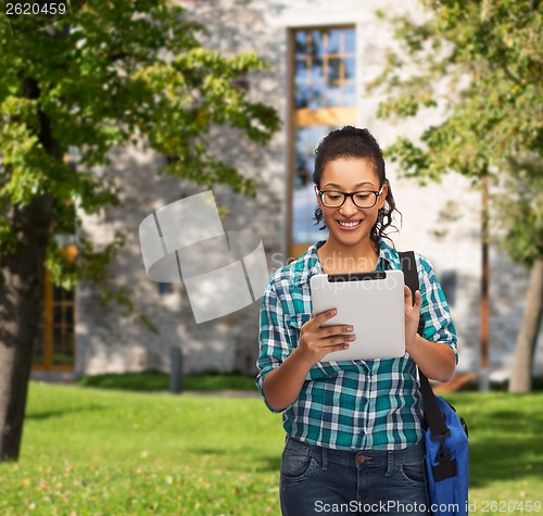 Image of student in eyeglasses with tablet pc and bag