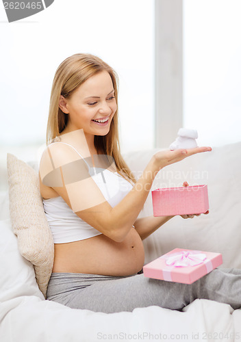 Image of smiling pregnant woman with gift box and bootees