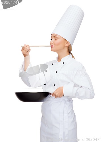 Image of smiling female chef with pan and spoon