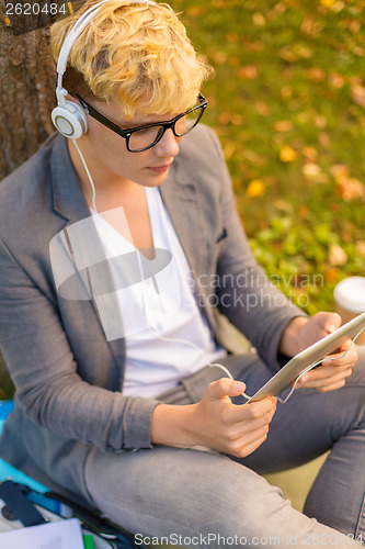 Image of smiling male student in eyeglasses with tablet pc