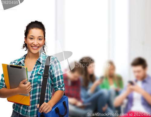 Image of smiling student with folders, tablet pc and bag