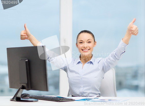 Image of woman with computer, papers showing thumbs up