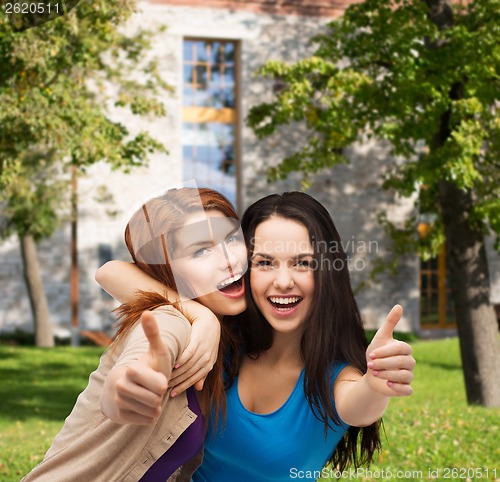 Image of two smiling girls showing thumbs up