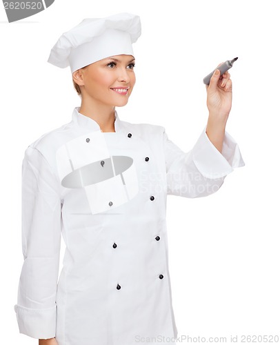 Image of smiling female chef writing something on air