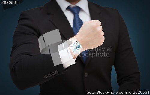 Image of businessman showing something at his hand