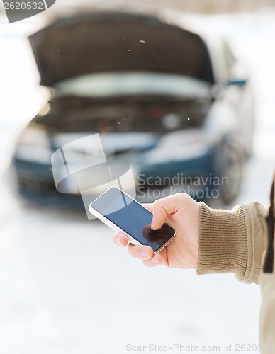 Image of closeup of man with broken car and cell tphone