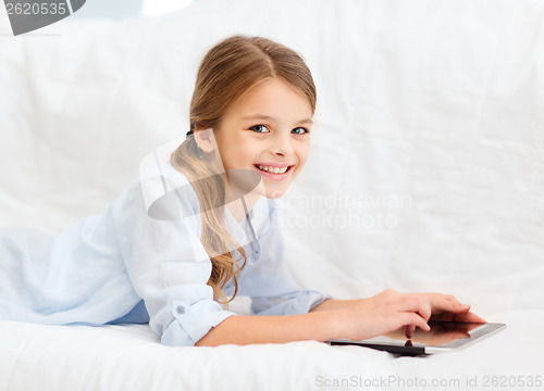 Image of smiling girl with tablet computer at home