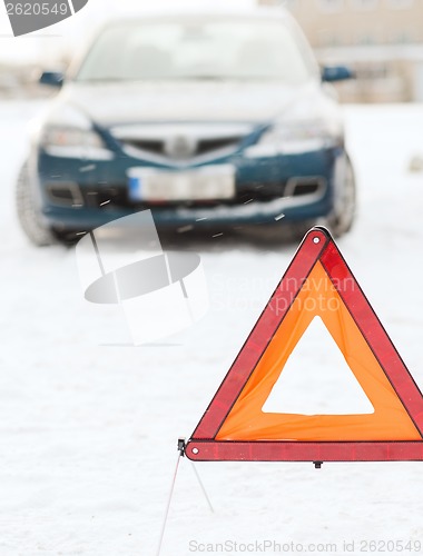 Image of closeup of warning triangle and car