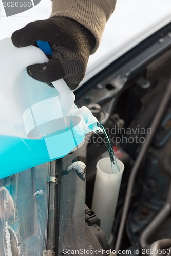 Image of closeup of man pouring antifreeze into water tank