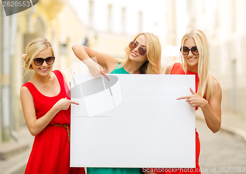 Image of three happy blonde women with blank white board