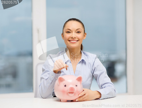 Image of smiling woman with piggy bank and cash money