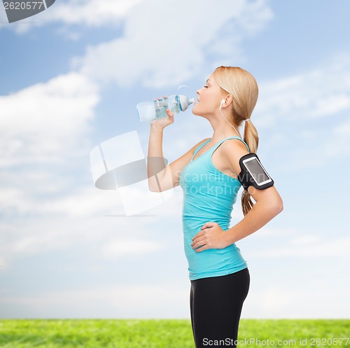 Image of sporty woman running with smartphone and earphones