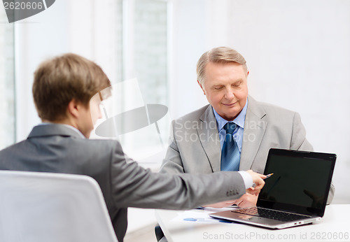 Image of older man and young man with laptop computer
