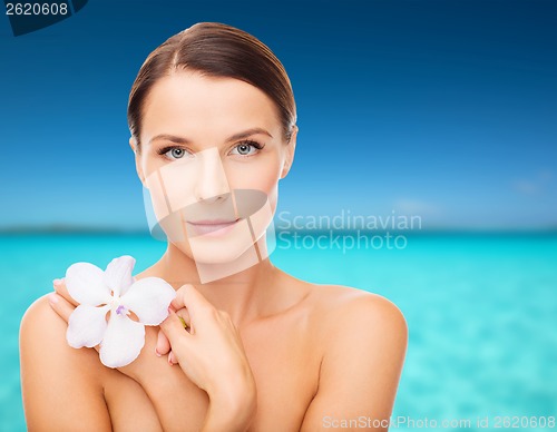 Image of relaxed woman with orhid flower