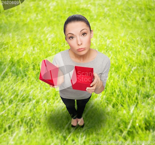 Image of disappointed asian woman with empty red gift box