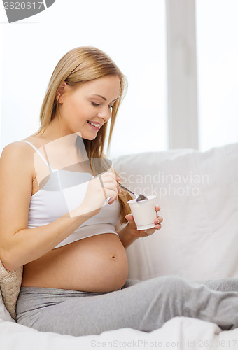 Image of happy pregnant woman with yogurt
